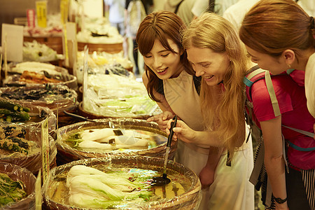 年轻美女带外国友人体验当地美食图片