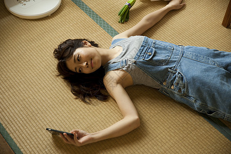 躺在地上乘凉看手机的女孩图片