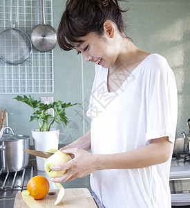 在厨房削苹果的女性图片