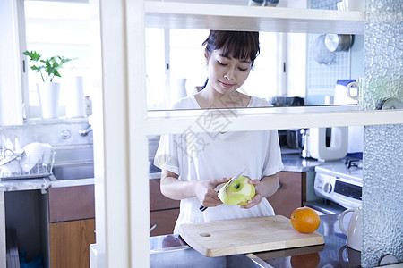 厨房水果削皮的居家女性图片