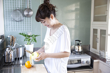 厨房水果削皮的居家女性图片