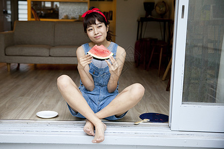 夏日女孩坐在窗边吃西瓜乘凉图片
