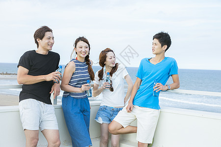 海边喝酒的青年情侣图片