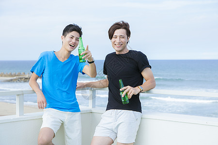 海边度假喝啤酒的青年图片