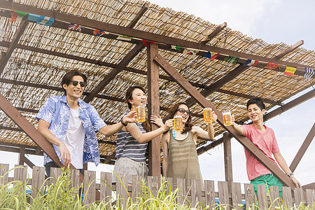 海边小屋喝啤酒聊天的青年图片