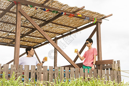 海边度假餐厅里男人女人一起喝啤酒图片