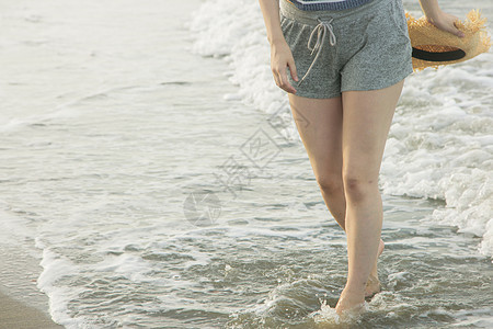 一个女人在沙滩上散步特写图片