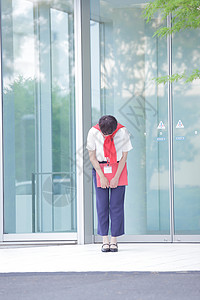 办公楼外躬身迎接客户的女性图片素材