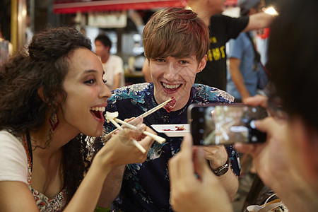 外国游客享受日本料理拍照留念图片