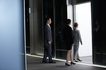 办公楼内走进电梯的3人商务人士图片素材