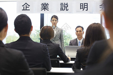 拿着话筒给求职者讲解注意事项的女白领图片