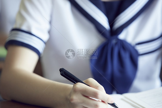 正在写字做题的学生手部特写图片