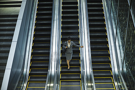办公楼自动扶梯上的商务人士图片