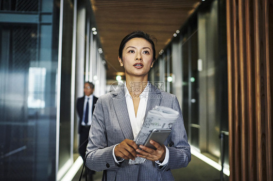 走进办公楼电梯厅的职场商务女性图片