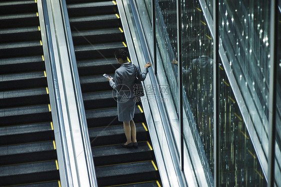 乘坐办公楼自动扶梯的女白领图片