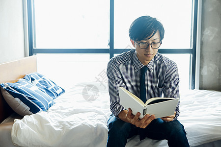 坐床上读书的男人图片