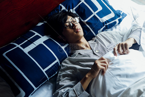 躺在床上休息的男人图片