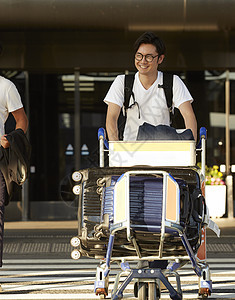 男人推着行李走出机场图片