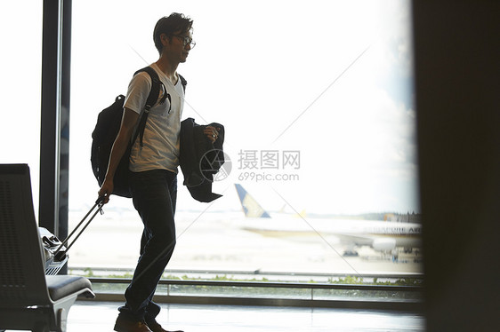 男子拖着行李走在机场大厅图片