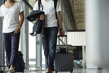 在机场拖着行李箱行走的2人图片素材