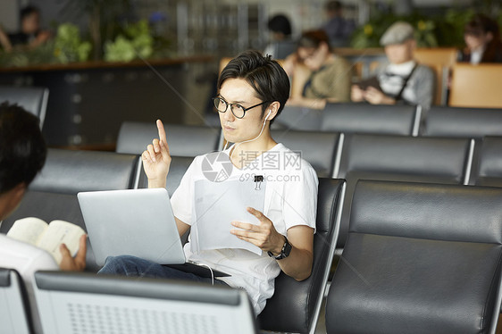 在机场用笔记本电脑工作的男性图片