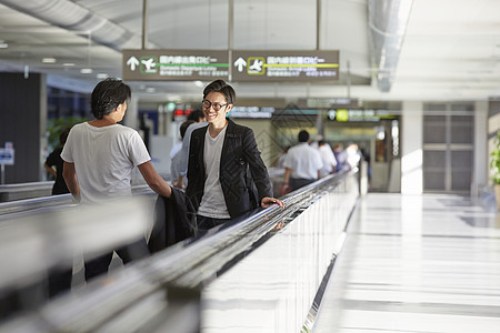 机场推行李乘坐扶梯的男人图片