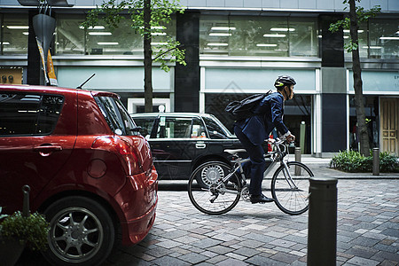 在街上骑自行车的西装男性图片