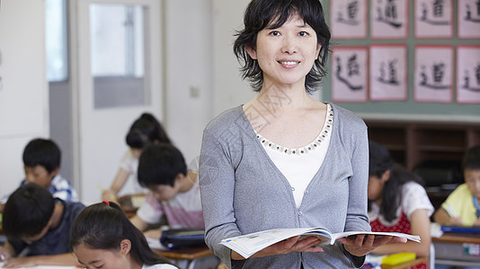 手捧书书本的女老师图片