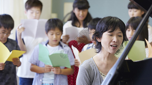 小学生音乐课教唱歌的老师背景图片