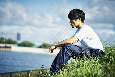 休息时间在草坪坐着的年轻男性图片