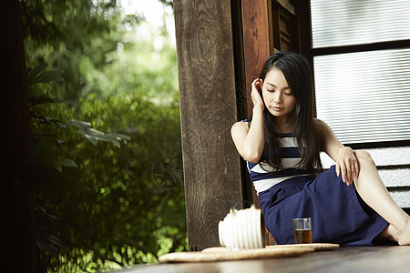 日式房屋中喝茶的女青年形象图片