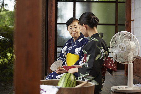 日式房屋中乘凉的穿和服的母女图片