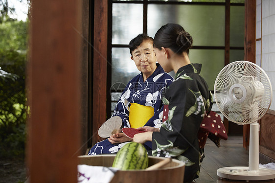 日式房屋中乘凉的穿和服的母女图片