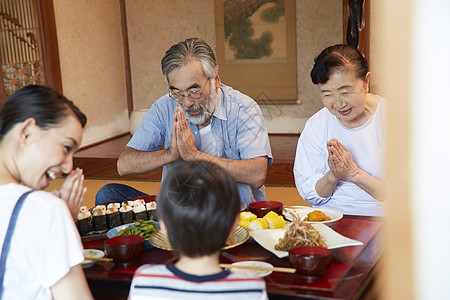 围坐在餐桌前吃饭的家人图片