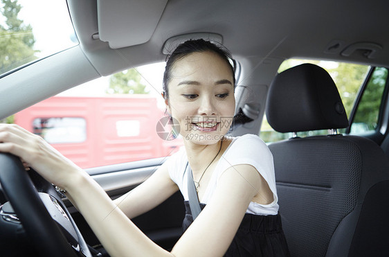 在汽车驾驶位上的年轻女性图片