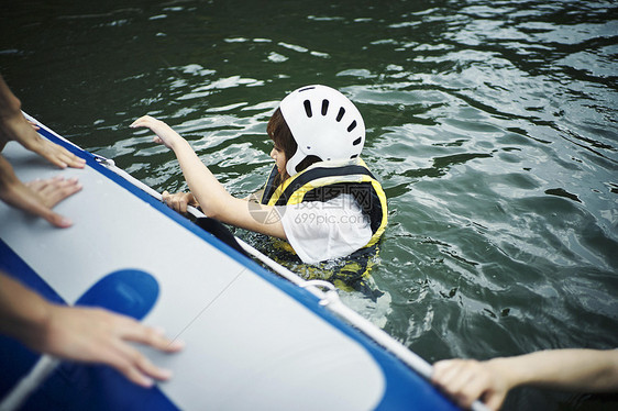 穿着救生衣在水里浮着的女青年图片