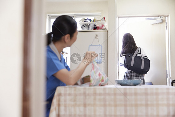 早上母亲用毛巾包便当盒和孩子准备上学图片