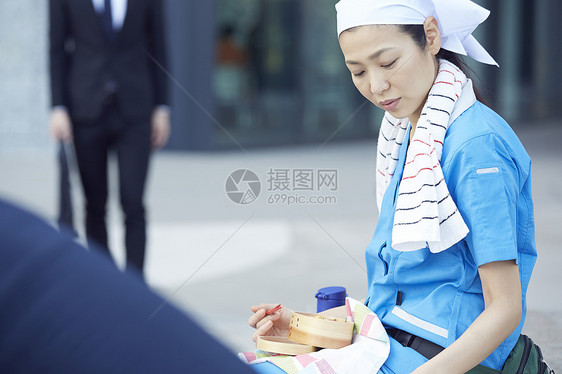 在办公楼下吃午餐的女清洁员图片