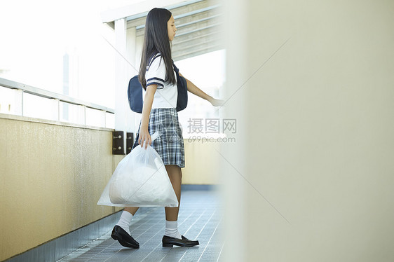  手提垃圾袋的女学生关门图片