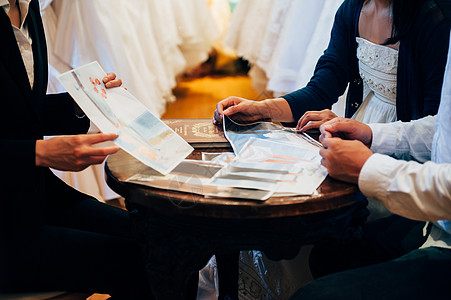 婚礼策划师与新娘新郎讨论礼服设计背景图片