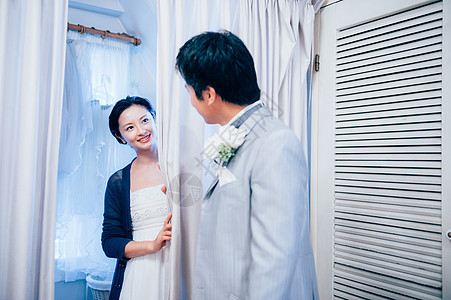 婚纱店试衣间对视的夫妇图片