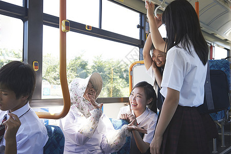 坐公交的奶奶开心的和学生交谈图片