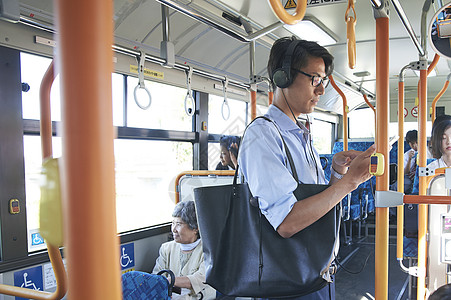 运输工具戴耳机坐公交车的男性背景