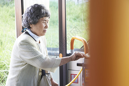 老年女性在公交车上刷卡投币图片
