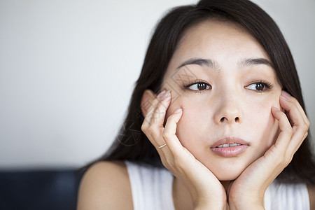 婚纱长托尾女生手托脸颊发呆背景