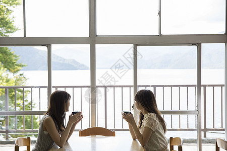 闺蜜二人在湖边的餐厅吃饭图片