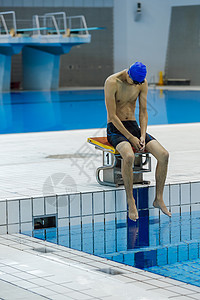 泳池边沉思的游泳运动员图片