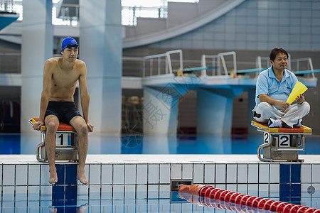 跳水运动员室内泳池训练的运动员和教练背景