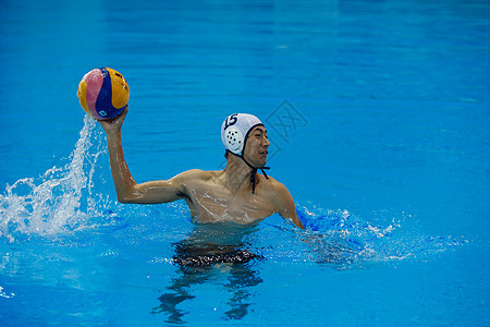 在水里拿着球锻炼的游泳运动员图片