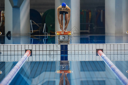 站在跳板上准备起跳的游泳运动员图片